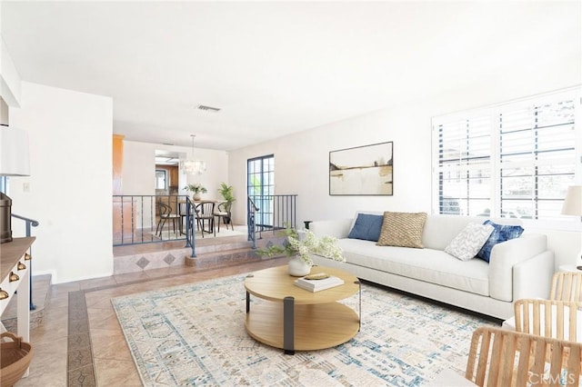 tiled living room featuring an inviting chandelier