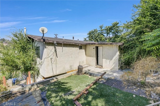 rear view of property featuring a lawn