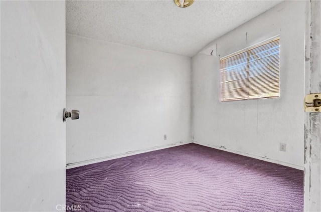 carpeted empty room with a textured ceiling