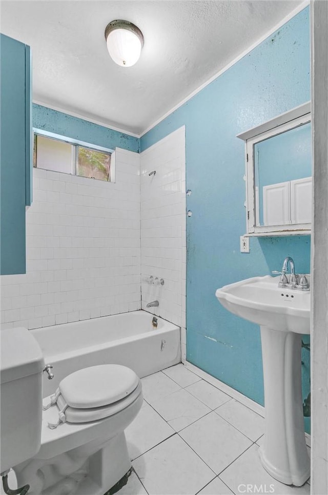 bathroom featuring tile patterned flooring, tiled shower / bath combo, and toilet