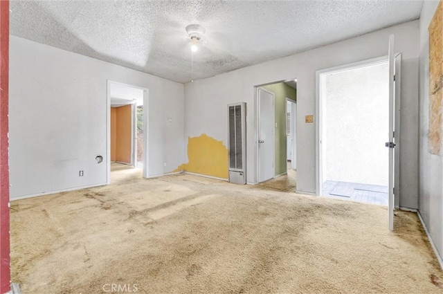 carpeted empty room with a textured ceiling