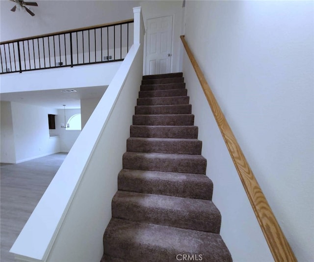 stairs featuring hardwood / wood-style floors and ceiling fan