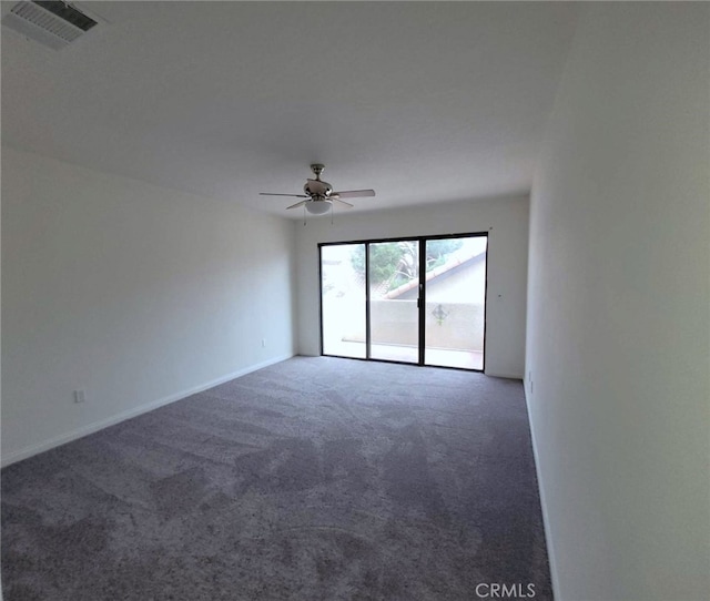 empty room with dark colored carpet and ceiling fan