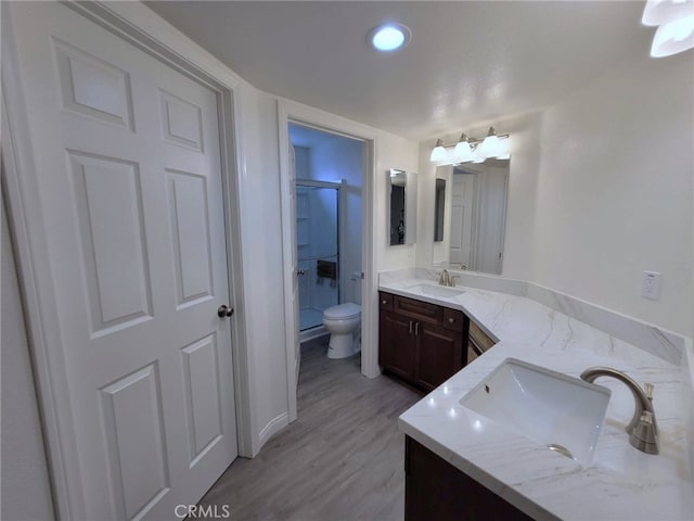 bathroom with an enclosed shower, wood-type flooring, vanity, and toilet