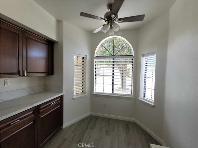 unfurnished dining area featuring ceiling fan and wood-type flooring