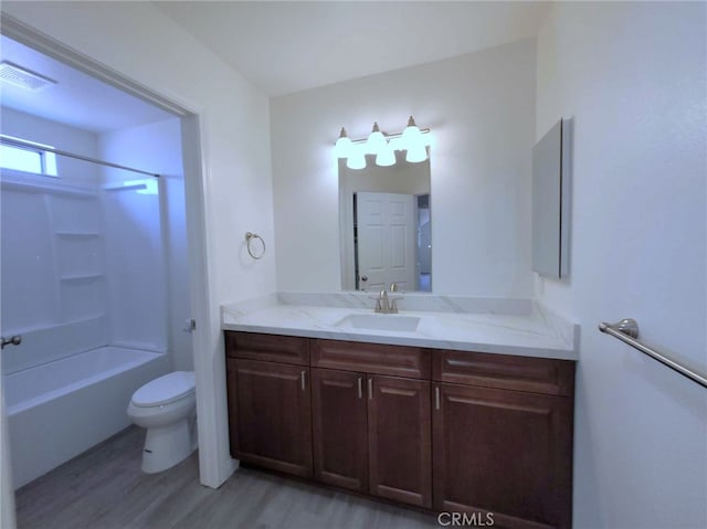 full bathroom featuring wood-type flooring, vanity, shower / bath combination, and toilet