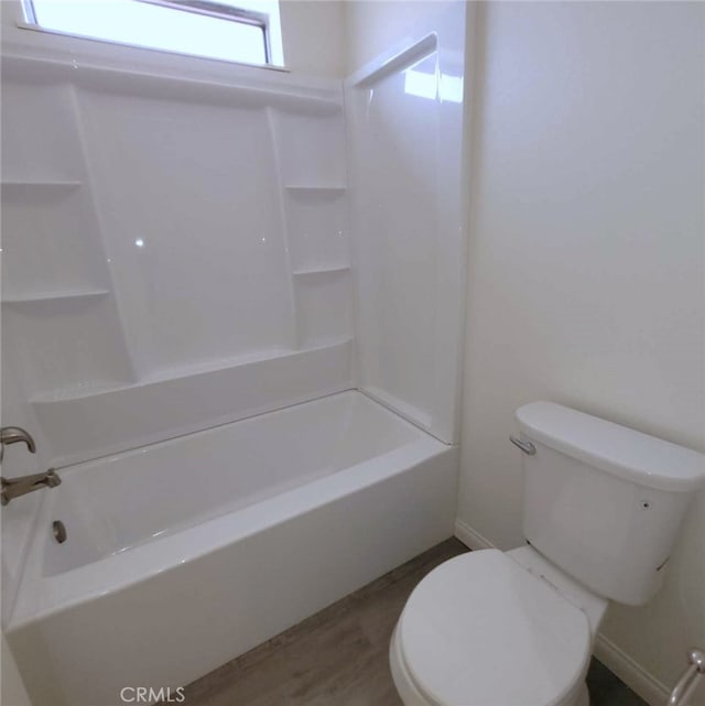 bathroom with wood-type flooring, bathtub / shower combination, and toilet