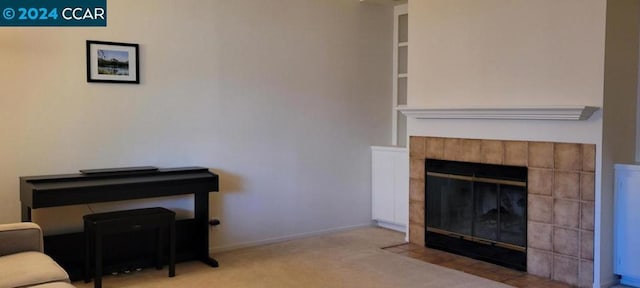 living room featuring light carpet and a tile fireplace