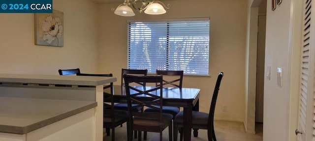 dining area featuring carpet floors and an inviting chandelier