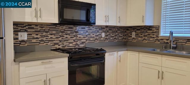 kitchen featuring sink, black appliances, white cabinetry, and backsplash