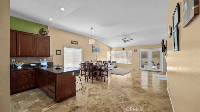 kitchen featuring ceiling fan, lofted ceiling, kitchen peninsula, and a healthy amount of sunlight