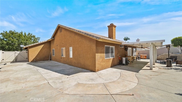 rear view of property featuring a patio and ceiling fan