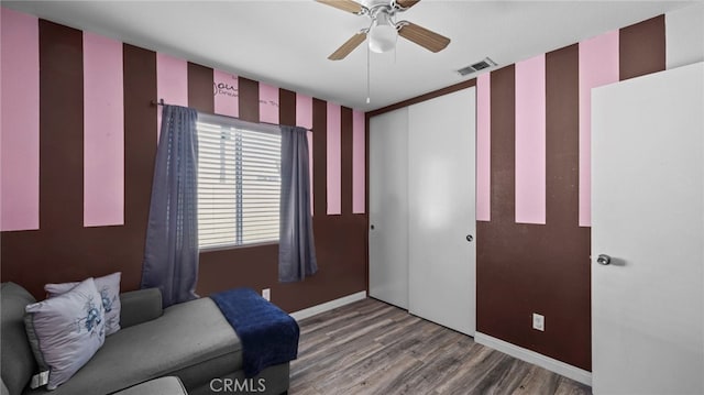 living area with wood-type flooring and ceiling fan