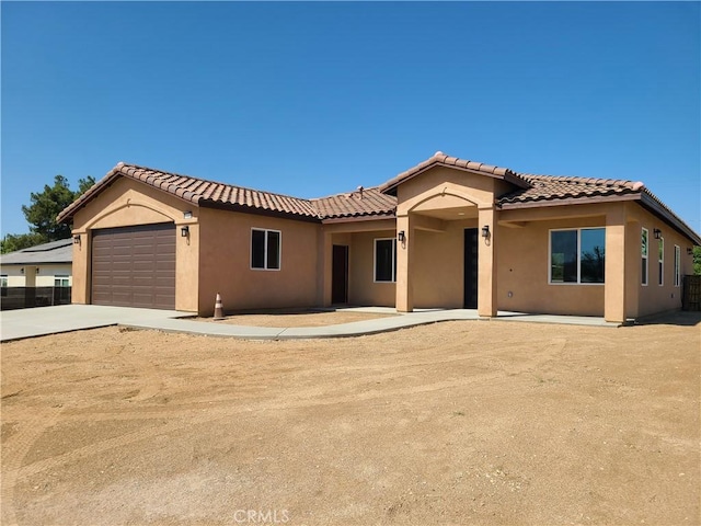 mediterranean / spanish-style home with a garage