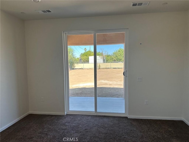 spare room featuring dark carpet