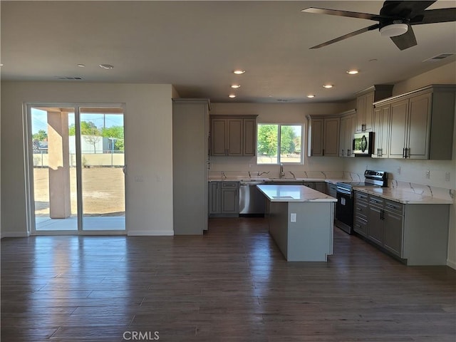 kitchen with gray cabinets, a center island, stainless steel appliances, and a wealth of natural light