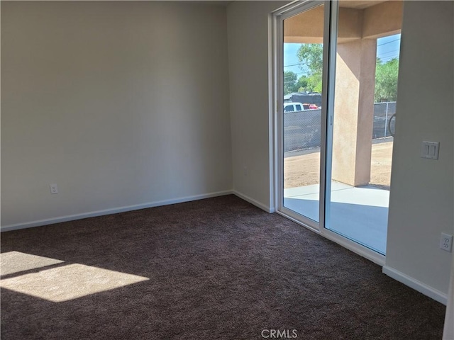 spare room with dark carpet