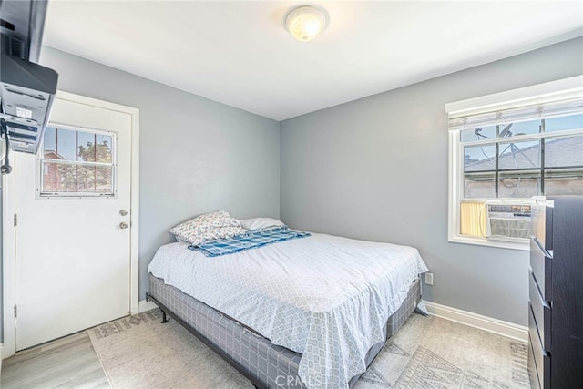 bedroom with light hardwood / wood-style flooring and cooling unit