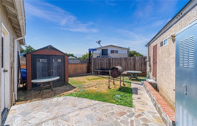 view of yard featuring a storage shed and a patio area