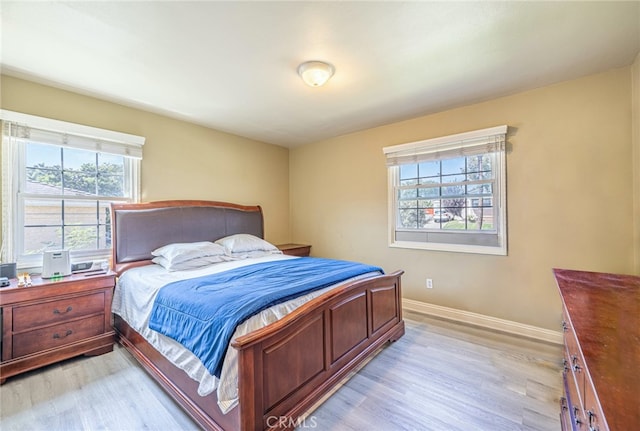 bedroom with light hardwood / wood-style flooring and multiple windows