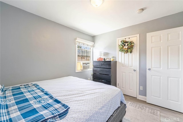 bedroom featuring light wood-type flooring and cooling unit