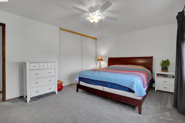 carpeted bedroom with a closet and ceiling fan