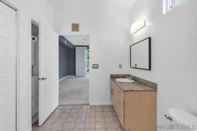 bathroom featuring vanity, a wealth of natural light, tile patterned floors, and toilet