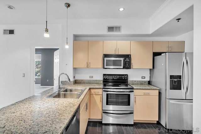 kitchen featuring pendant lighting, stainless steel appliances, sink, and light brown cabinets