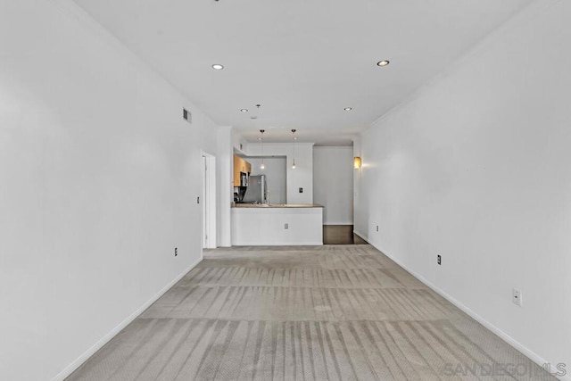 unfurnished living room featuring light colored carpet