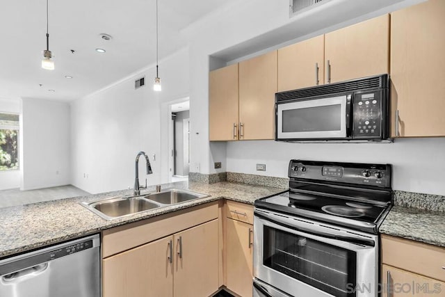 kitchen with appliances with stainless steel finishes, sink, pendant lighting, and light brown cabinetry