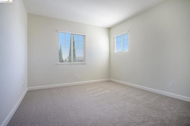 carpeted empty room with a healthy amount of sunlight