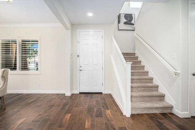 foyer entrance with crown molding and dark wood-type flooring