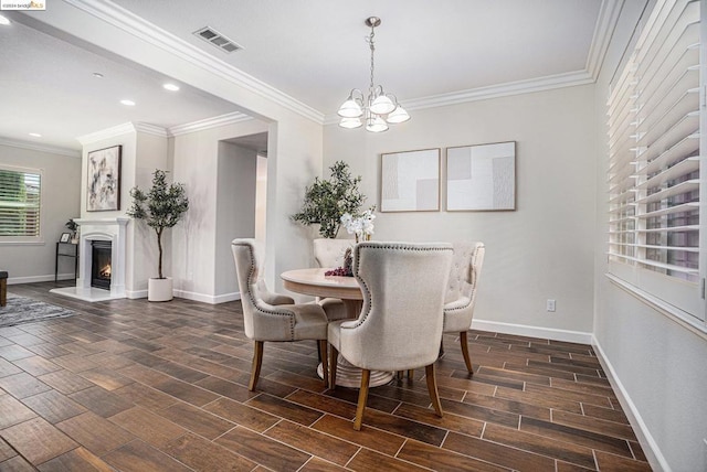 dining space featuring dark hardwood / wood-style flooring, ornamental molding, and a chandelier