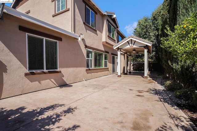 exterior space with ceiling fan and a patio