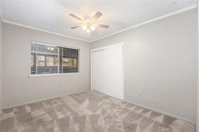 unfurnished bedroom with a textured ceiling, ceiling fan, light carpet, and a closet