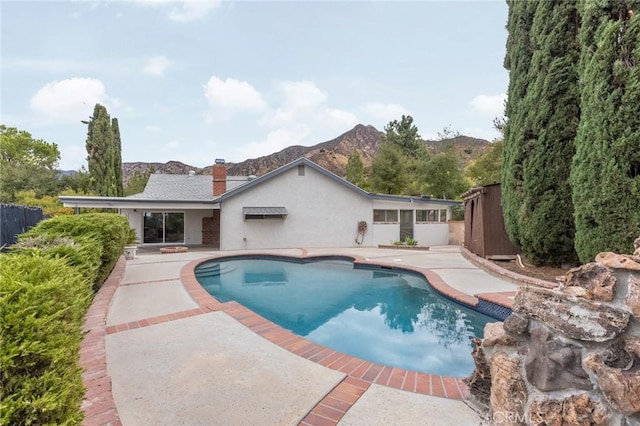 view of swimming pool featuring a mountain view and a patio