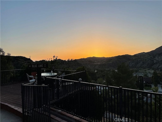 deck at dusk featuring a mountain view