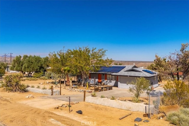 view of front of home featuring solar panels and a garage