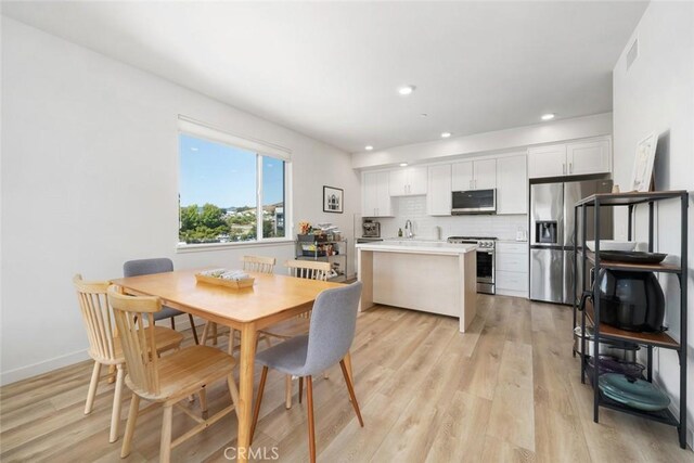 dining area with light hardwood / wood-style flooring and sink