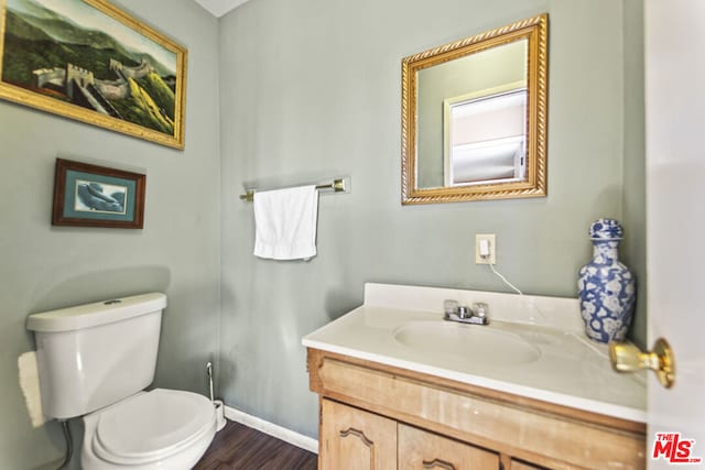 bathroom with vanity, toilet, and hardwood / wood-style flooring