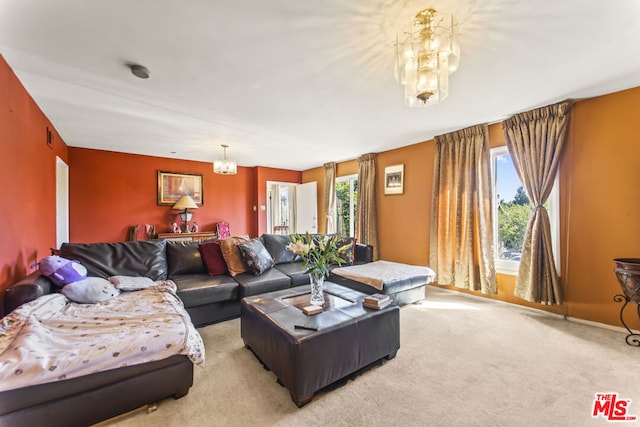 carpeted living room with an inviting chandelier