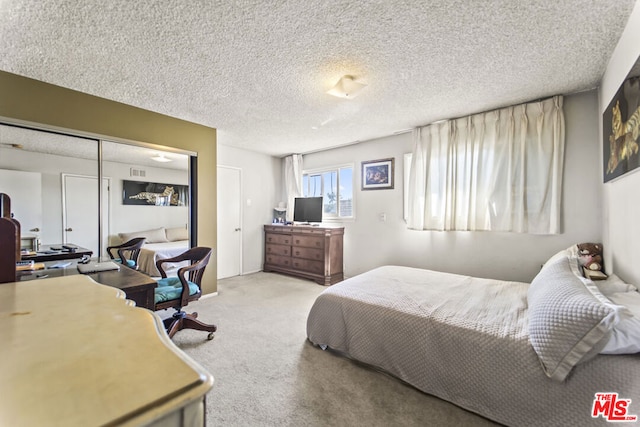 bedroom featuring light carpet, a closet, and a textured ceiling