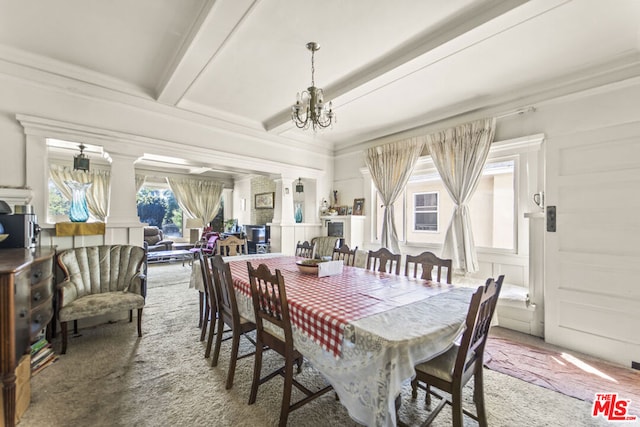 carpeted dining area with an inviting chandelier, ornamental molding, beamed ceiling, and ornate columns