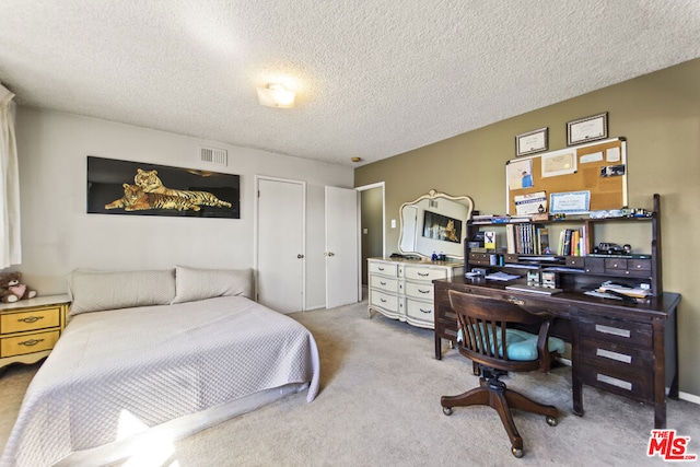 bedroom featuring light colored carpet and a textured ceiling