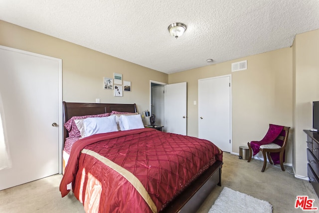 carpeted bedroom with a textured ceiling