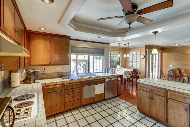 kitchen with sink, hanging light fixtures, white stovetop, stainless steel dishwasher, and tile counters