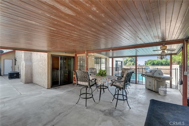 sunroom with ceiling fan and wood ceiling