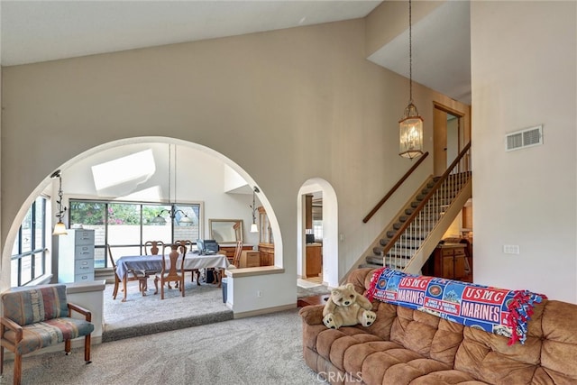 living room with high vaulted ceiling and carpet