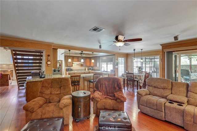 living room featuring ornamental molding, hardwood / wood-style floors, and ceiling fan