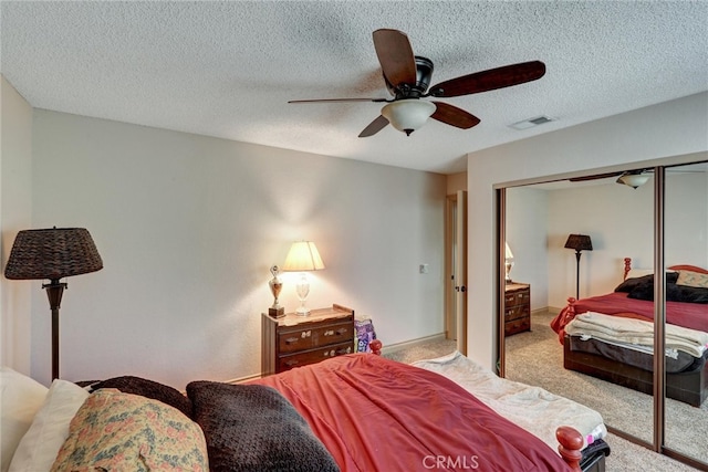 carpeted bedroom with a textured ceiling, a closet, and ceiling fan